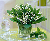 Convallaria majalis (Lily of the valley) in glass on cake plate