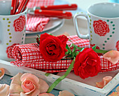 Napkin decoration with pink (rose petals), cups with rose decoration