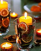 Glas mit getrockneten Orangenscheiben und Kerze