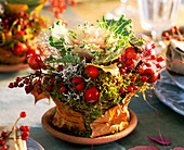 Brassica (ornamental cabbage), pot wrapped with moss, leaves, Rosa (rosehips), caloc