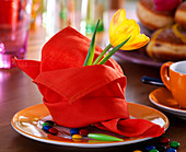 Rote Serviette gefaltet, Tulipa / Tulpe, Smarties, oranger