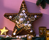 Wooden star glued and filled with cinnamon sticks, with baubles, nuts, sugar, citrus