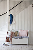 Chest bench against staircase in rustic hallway