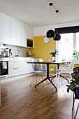 Modern dining table in kitchen-dining room with yellow wall