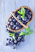 Blueberries in a basket on a blue wooden background