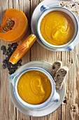 Pumpkin soup in bowls on a wooden background