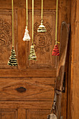 Crocheted Christmas trees in front of old wooden door and skis