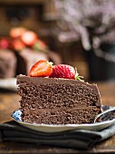Piece of paleo (floverless and gluten free) chocolate cake with strawberries