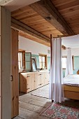 Canopied bed and walls painted green and white in rustic bedroom