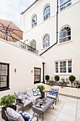 Seating area on terrace outside house with arched windows