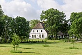 Giebelfassade von traditionellem, friesischem Bauernhaus aus dem 17. Jahrhundert mit Gartenanlage