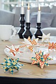 Colourful paper origami stars on a white dish