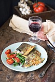 Pan-fried fish with tomatoes, garlic, green beans and a glass of red wine