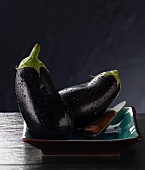 Two aubergines on a plate with a knife