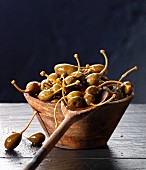 Giant capers in a wooden bowl and on a wooden spoon