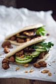 Vegane Bao-Tacos mit Sojageschnetzeltem, Salatgurke, Shiitakepilzen, gerösteten Erdnüssen und Sesam