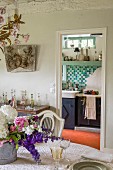 Blick von Essbereich in Küche mit türkisfarbenen Wandfliesen