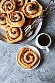 Puff pastry cinnamon rolls on tray with a cup of coffee