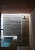Bad mit Betonwänden und Wanne aus Beton im Stil des Brutalismus