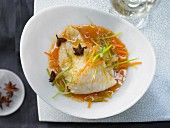 Steamed wolf fish fillet with julienne vegetables and a carrot and orange sauce with star anise