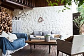 Lounge area on terrace with firewood stacked against wall