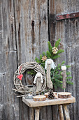 DIY-Engel aus Treibholz auf Holzschemel vor Holztür
