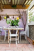 Table and chairs on Mediterranean terrace with lilac back wall