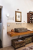 Stone sink and old wooden crates used for storage in bathroom