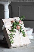 Romantisch verpacktes Geschenk mit Rosenblüten und Efeuranken