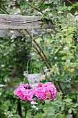 Candle lantern in wreath of pink hydrangeas hung from wooden beam