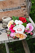 Bouquet of roses in various colours on weathered wooden table