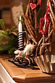 Christmas arrangement of rustic twig wreath, candle, rocking horse ornament and old bundt cake tin