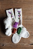 Gestrickte Wollsocken mit Blumen bestickt und passende Wolle
