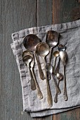 Selection of vintage silver spoons on a grey linen napkin