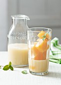 Fruity coconut drink with peach juice ice cubes (lactose-free)