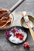 Cake decorations: chocolate cream, sugar icing, sugared berries and flowers