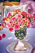 Elegant vase of roses on garden table