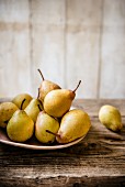 Pears on a plate against wooden surface, rustic