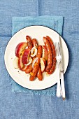 Sausages baked with onion, apple and apricot jam