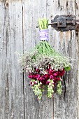 Bouquet of stocks and sea lavender hung from door