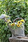Vintage Giesskanne mit Sonnenblumen und Clematisranke verziert