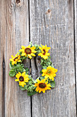 Wreath of sunflowers on wooden surface