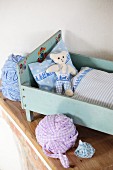 Hand-made bed linen and teddy bear in vintage dolls' bed