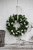 Wreath of box and honesty on white board wall