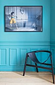 Black designer chair against turquoise wall