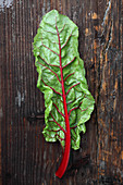 A chard leaf on a wooden surface