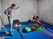 A base jumper folding and packing his parachute at Monte Brento, Italy