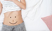 A smiley face drawn on a woman's stomach