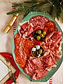Aufschnittplatte mit Salami, Rohschinken, Oliven und Feta (weihnachtlich)