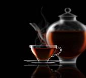 Black tea, glass teacup, saucer and teapot